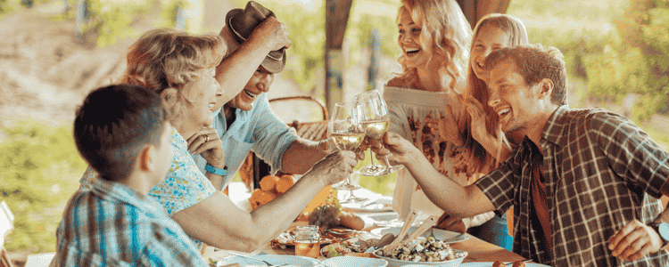 A family gathered around the table, smiling and raising their glass